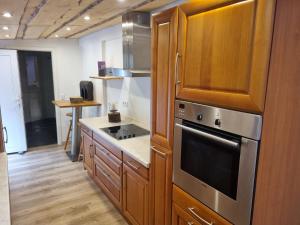 a kitchen with wooden cabinets and a stove top oven at Ferien- und Monteurwohnung Grünstadt-Worms in Obrigheim +7 photos