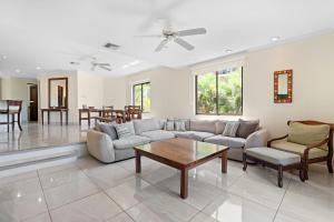 uma sala de estar com um sofá e uma mesa em Recently Renovated Luxury Condo with Resort-Style Beach Club Access and Ocean Views em Playa Conchal