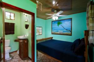 大玉米岛Hospedaje Rosa Del Mar & Sweets Cafe的一间卧室配有一张床、一个水槽和吊扇