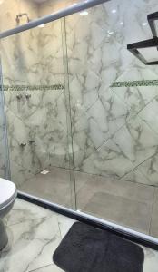 ミゲウ・ペレイラにあるAconchego IVのガラス張りのシャワーとトイレ付きのバスルーム
