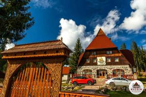een gebouw met een auto ervoor geparkeerd bij Bucsin menedékház in Bucin
