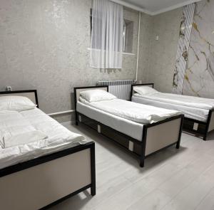 zwei Betten in einem Zimmer mit in der Unterkunft AI Hostel in Bischkek