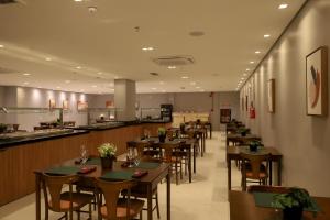 a restaurant with tables and chairs and a bar at Bristol Castanhal Hotel in Castanhal