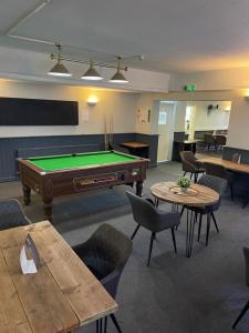 a room with a pool table and tables and chairs at The Pheasant Inn in Dunstable