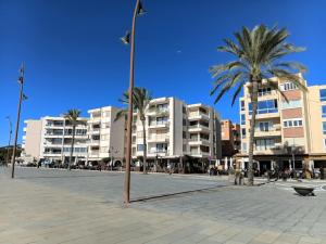 a street with palm trees in front of buildings at Apartamento en Moraira con piscina 100 m de la playa in Moraira