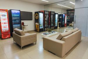 una hall con due sedie e due videogiochi di Lagoa Flat Hotel a Lagoa da Prata Altre 34 foto