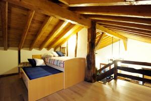 サールにあるAnikunbordaの木製の天井の部屋にあるベッドのある寝室