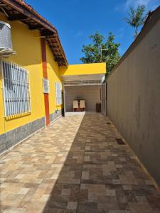 a yellow building with a garage with a table at Casa Praia Bertioga in Bertioga