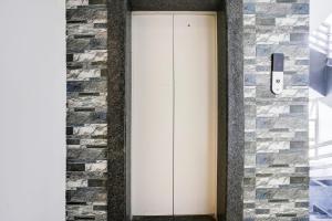 a white door in a brick wall at Super Hotel O Nashik Road Formerly The Address Hotel in Nashik