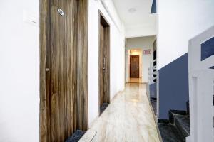 a hallway with a wooden door and stairs at Super Hotel O Nashik Road Formerly The Address Hotel in Nashik