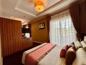 D' Leonor Inland Resort and Adventure Park في مدينة دافاو: غرفة نوم بسرير كبير ونافذة