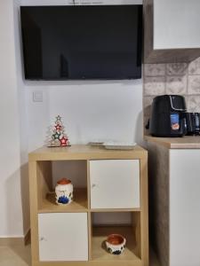 ガラヒディにあるAeolus Apartment IIのテレビと棚付きのテーブルがあるリビングルーム