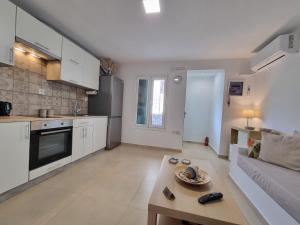 ガラヒディにあるAeolus Apartment IIのソファとテーブルのあるキッチンとリビングルーム