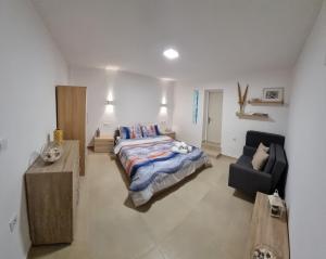 ガラヒディにあるAeolus Apartment IIの広いベッドルーム(ベッド1台、椅子付)