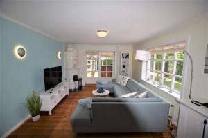 ein Wohnzimmer mit Sofa und Fernseher in der Unterkunft Haus am Strandweg in Hohwacht