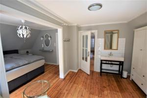 ein Schlafzimmer mit einem Bett, einem Waschbecken und einem Spiegel in der Unterkunft Haus am Strandweg in Hohwacht