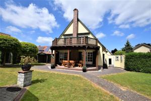 ein Haus mit einem Gamer-Dach und einer Terrasse in der Unterkunft Haus am Strandweg in Hohwacht