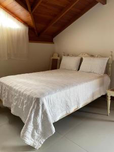 En eller flere senge i et værelse på Kitnet Completa Com Vista Para o Lago