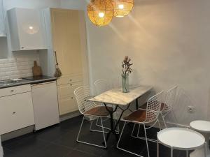 a kitchen with a table with chairs and a vase with flowers at Sainte Apartments in Marseille