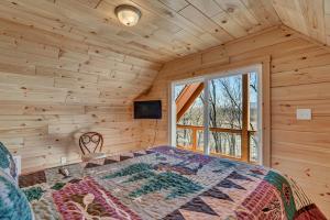 ein Schlafzimmer mit einem Bett in einer Blockhütte in der Unterkunft Cozy, Luxurious Fox Den in the Shenandoah Valley in Oak Hill