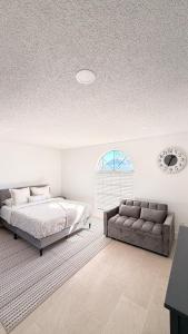 a bedroom with a bed and a couch at Hermoso apartaestudio en Orlando in Orlando