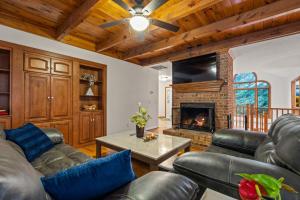 ein Wohnzimmer mit Ledermöbeln und Kamin in der Unterkunft Green Mountain Song-Massanutten Mountain in Massanutten