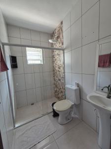 a bathroom with a shower and a toilet and a sink at Casa Praia Bertioga in Bertioga +11 photos