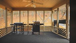 eine überdachte Veranda mit Deckenventilator und zwei Tischen in der Unterkunft Green Mountain Song-Massanutten Mountain in Massanutten