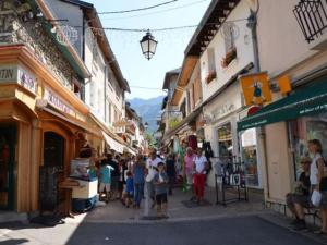 a group of people walking down a street with buildings at Appartement cosy en centre-ville, proche pistes, 4 pers - FR-1-515-216 in Villard-de-Lans