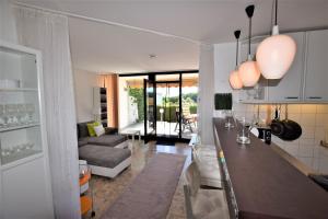 eine Küche und ein Wohnzimmer mit einer Bar und einem Sofa in der Unterkunft Hohes Ufer Mare Nostrum in Hohwacht