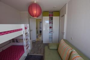 ein kleines Zimmer mit einem Etagenbett und einer Lampe in der Unterkunft Hohes Ufer Mare Nostrum in Hohwacht