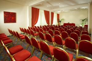 a conference room with red chairs and a table at Hotel Caparena in Taormina