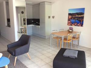 a living room with a dining room table and chairs at Lido Golf by Fewotessin in Ascona