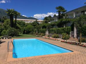 a large blue swimming pool in front of a building at Lido Golf by Fewotessin in Ascona