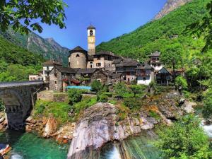 a village on a mountain with a bridge and water at Lido Golf by Fewotessin in Ascona