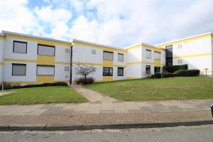 eine Reihe weißer und gelber Wohnhäuser in der Unterkunft Hohes Ufer Sandburg in Hohwacht