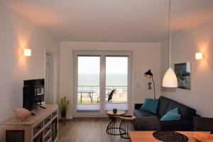 a living room with a couch and a window at Meeresblick "Seepferdchen" Haus 3 WE 42 in Hohwacht