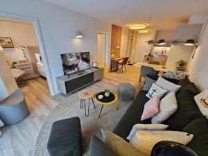 a living room with a couch and a tv at Meeresblick Appartement 33 H3 WE 33 in Hohwacht