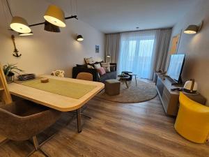 a living room with a table and a living room with a couch at Meeresblick Appartement 33 H3 WE 33 in Hohwacht