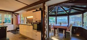 Ferienhaus FH6 في غرال موريتز: مطبخ مع طاولة وكراسي وبعض النوافذ