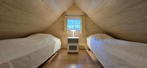 Ferienhaus FH6 في غرال موريتز: سريرين في غرفة صغيرة بها نافذة