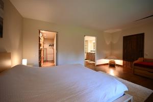 a bedroom with a large white bed in a room at Le Nid d'à côté in Méan