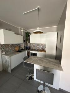 a kitchen with white cabinets and a marble counter top at MXP-Milano-Torino Loft in Inveruno