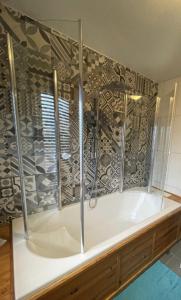 eine Badewanne mit Glaskabine im Bad in der Unterkunft Les Grosses Pierres in Spa