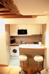 een keuken met een aanrecht en 2 krukken bij Studio Aboukir in Parijs