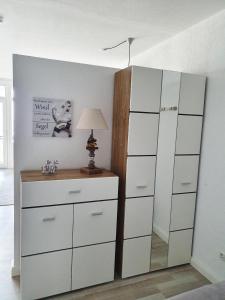 una camera da letto con una cassettiera e un grande armadio bianco di Vier Jahreszeiten Haus 2 Whg 27 a Grossenbrode