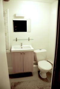 パリにあるスタジオ アブキルの白いバスルーム(トイレ、シンク付)