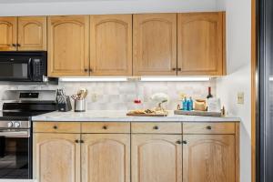 a kitchen with wooden cabinets and a counter top at Mountain View Condo - Hot Tub Fireplace in Avon