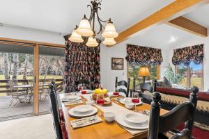 a dining room with a table and chairs and a room with a balcony at Mountain View Condo - Hot Tub Fireplace in Avon