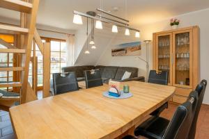 una sala da pranzo con tavolo e sedie in legno di Ferienpark Freesenbruch Wohnung 2 4 - Familientraum a Zingst